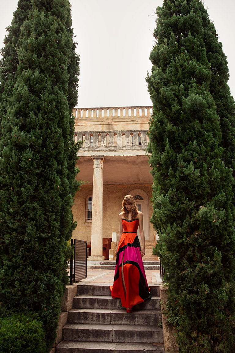 une femme en robe longue montant les escaliers