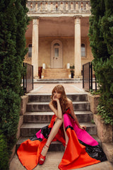 femme dans une robe rouge assise sur un ensemble d’escaliers