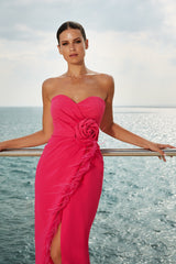 femme dans une robe rose debout sur un balcon surplombant l’océan, robe bustier, longue robe fluide luxueuse