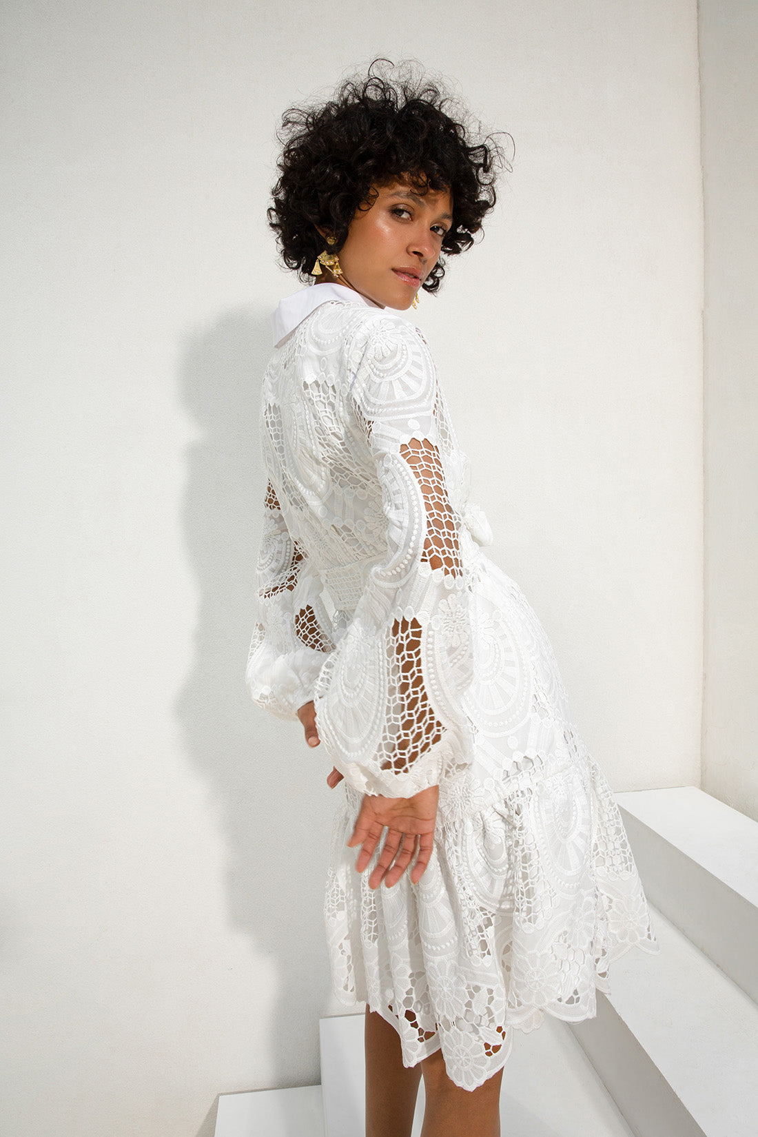 femme en robe blanche debout sur les escaliers dans la chambre blanche, robe blanche complexe