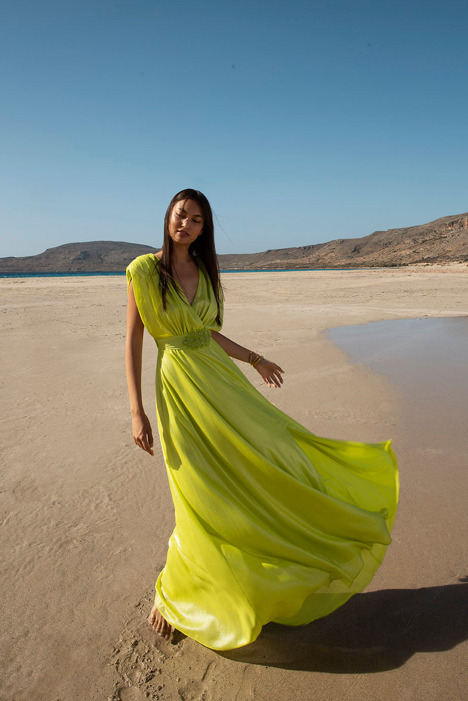 femme dans une robe jaune marchant sur une plage, robe fluide, soie fluo fluide, portant une robe fluide, portant une robe vert fluo, robe fluide, teinte citron vert et or